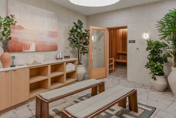 A room with a wooden bench and a painting on the wall.